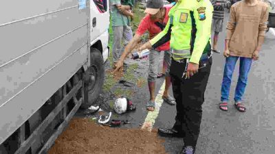 Petugas melakukan olah TKP yang menewaskan pengendara RX King usai dilindas Truk Box di Pacitan