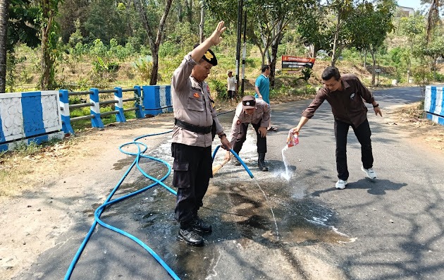 Petugas bergerak cepat membersihkan tumpahan solar yang membasahi badan jalan di kawasan Dukuh Putuk Suren, Desa Singgahan, Kecamatan Pulung